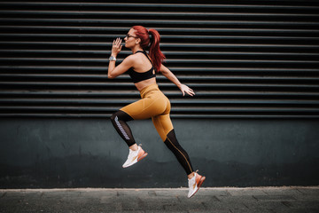Sports and fitness concept - Sexy woman with fit body jumping and running, exercising