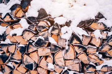 background, texture of firewood in winter with snow.