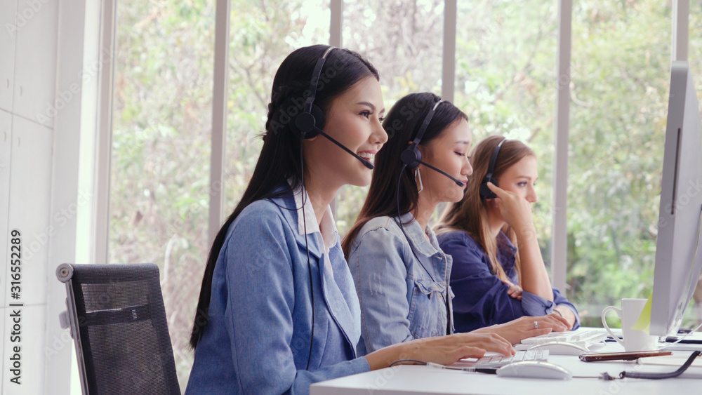 Aufkleber customer support agent or call center with headset works on desktop computer while supporting the cu