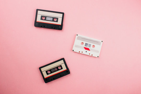 Retro audio cassette flat lay on colorful blue pink pastel background. Top view with copy space. Creative fashion design in minimal 80-s style. Music, radio, dj concept. Template for web. Stock photo.