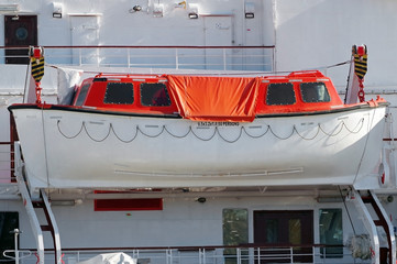 Red lifeboat docked to ship
