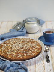 Homemade baking. Round apple pie with a blue napkin on a wooden white rustic table.