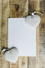 Rustic Valentines day background with toy hearts over wooden table. Place for text.