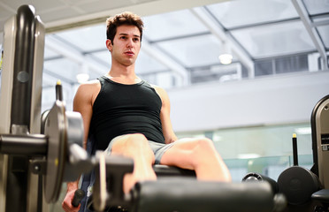 Fototapeta na wymiar Gym seated leg curl machine exercise man in the gym