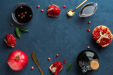 Frame of pomegranates and pomegranate sauce on a blue background