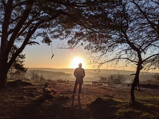 silhouette of man at sunrise, from top of a hill