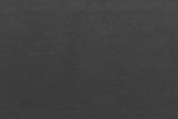Cardboard black abstract texture close-up. Dark old paper background. Grunge concrete wall. Vintage blank wallpaper.