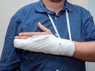 ..Close up hand of man with bandage and gypsum. a broken plastered arm after accident.