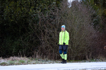 Happy woman tourist trains nordic walking in the cold morning. Healthy concept.