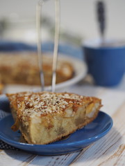 Sliced slice of apple pie with crushed walnuts. Homemade baking.