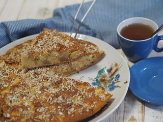 Sliced slice of apple pie with crushed walnuts. Homemade baking.
