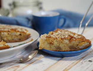 Sliced slice of apple pie with crushed walnuts. Homemade baking.