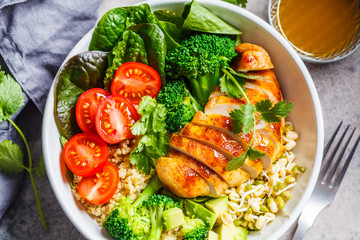 Balanced food concept. Chicken, broccoli and quinoa salad in white bowl, gray background, top view.