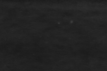 Cardboard black abstract texture close-up. Dark old paper background. Grunge concrete wall. Vintage blank wallpaper.