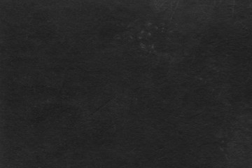 Cardboard black abstract texture close-up. Dark old paper background. Grunge concrete wall. Vintage blank wallpaper.