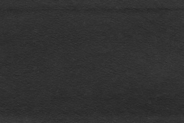 Cardboard black abstract texture close-up. Dark old paper background. Grunge concrete wall. Vintage blank wallpaper.