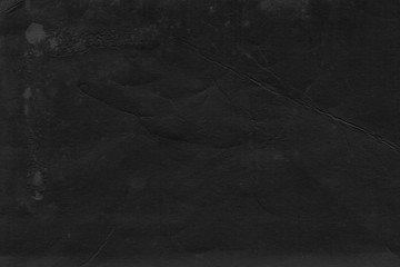Cardboard black abstract texture close-up. Dark old paper background. Grunge concrete wall. Vintage blank wallpaper.