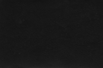 Cardboard black abstract texture close-up. Dark old paper background. Grunge concrete wall. Vintage blank wallpaper.
