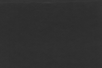 Cardboard black abstract texture close-up. Dark old paper background. Grunge concrete wall. Vintage blank wallpaper.