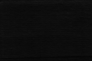 Cardboard black abstract texture close-up. Dark old paper background. Grunge concrete wall. Vintage blank wallpaper.