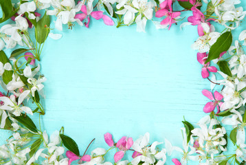 Frame of spring flowers on blue wooden background