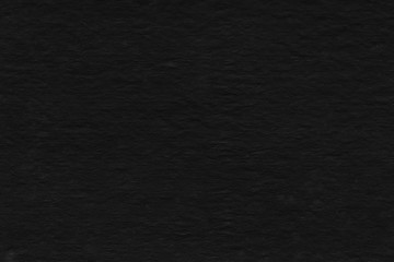 Cardboard black abstract texture close-up. Dark old paper background. Grunge concrete wall. Vintage blank wallpaper.