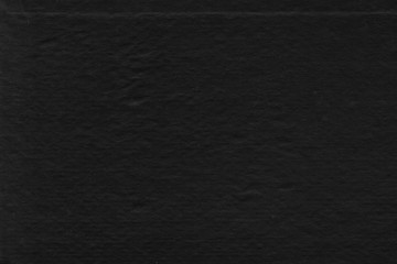 Cardboard black abstract texture close-up. Dark old paper background. Grunge concrete wall. Vintage blank wallpaper.