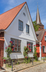 White house with red flowers in Plon, Germany