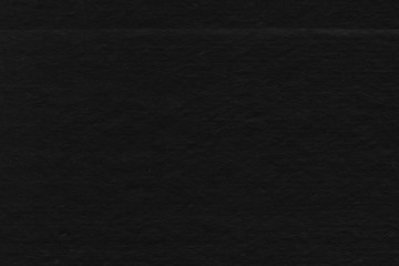 Cardboard black abstract texture close-up. Dark old paper background. Grunge concrete wall. Vintage blank wallpaper.