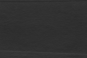 Cardboard black abstract texture close-up. Dark old paper background. Grunge concrete wall. Vintage blank wallpaper.