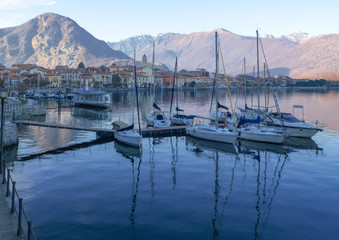 Fototapeta na wymiar sailboats moored in front of feriolo, a characteristic town with a tourist vocation on the Piedmont coast of lake maggiore
