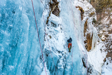 Ice Climbing Woman with an Ice Axe and Crampons on a Frozen Waterfall in the Taschachschlucht (Taschach Valley) in the Pitztal in Austria