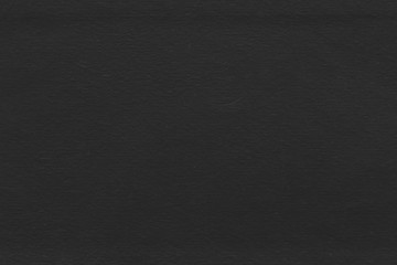 Cardboard black abstract texture close-up. Dark old paper background. Grunge concrete wall. Vintage blank wallpaper.