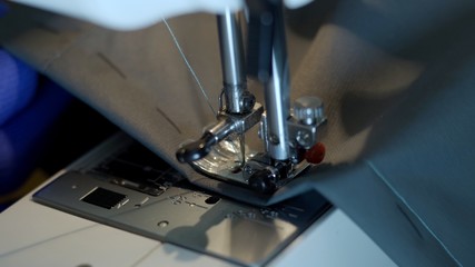Close-up of sewing machine needle rapidly moves up and down. 