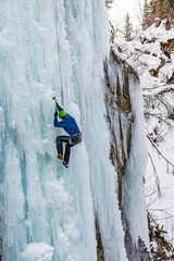 Ice Climbing Man with an Ice Axe and Crampons on a Frozen Waterfall in the Taschachschlucht (Taschach Valley) in the Pitztal in Austria