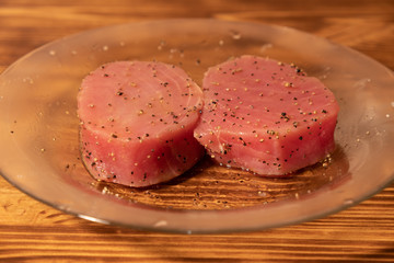 Fresh raw tuna fillet for steak on plate. Tasty fish dinner. Ingredients for cooking