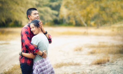 Happy couple having fun in autumn. Happy young couple hugging and laughing outdoors. 