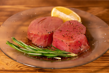 Fresh raw tuna fillet for steak on plate. Tasty fish dinner. Ingredients for cooking