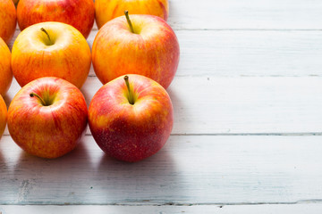 apple fruits in a row, white wooden table background