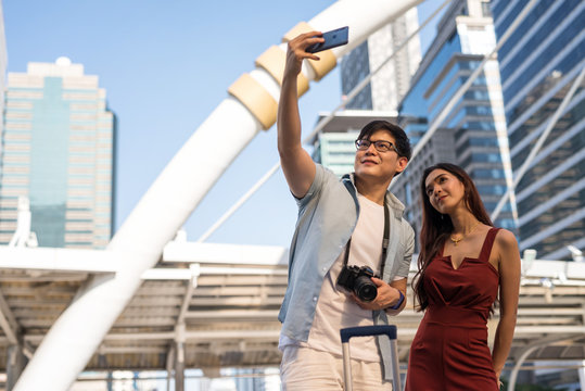 Asian tourist couple selfie in city