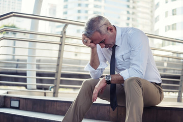 Depressed senior businessman in city