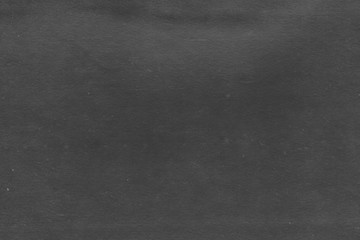 Cardboard black abstract texture close-up. Dark old paper background. Grunge concrete wall. Vintage blank wallpaper.