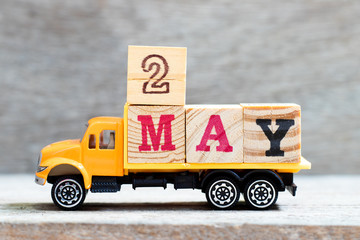 Truck hold letter block in word 2may on wood background (Concept for date 2 month May)