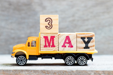 Truck hold letter block in word 3may on wood background (Concept for date 3 month May)