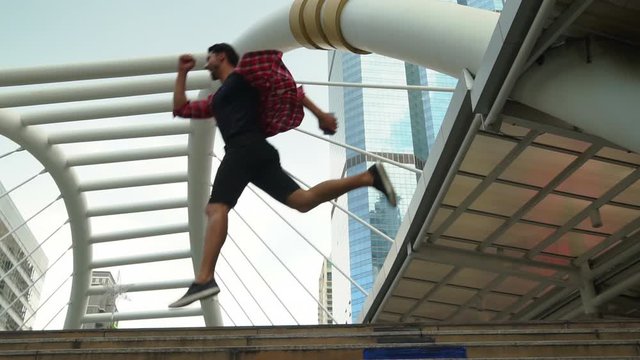 Slow motion. Handsome traveler man jumping to the air in the city. Attractive handsome guy get happiness because he get holiday, vacation time. Cool guy get freedom, happiness. He travel alone at Asia