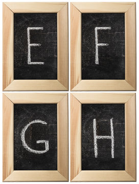 Part of the alphabet drawing with chalk on the old scratched chalkboard background with wooden frame. Letters: E, F, G, H. The other letters of this alphabet can be found in my partfolio