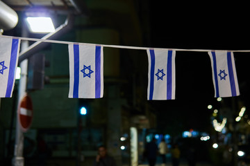 Israel flags hanging on the rope on the night street