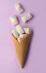 ice cream cone  files with candies isolated on violet background