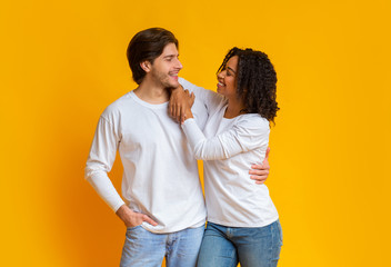 Romantic interracial couple cuddling and looking at each other