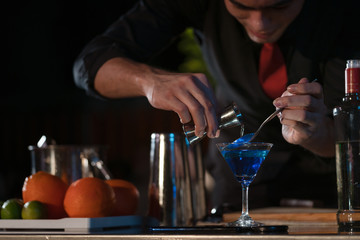 Bartender at night party, Bartender pouring the ingredients into a cocktail glass.